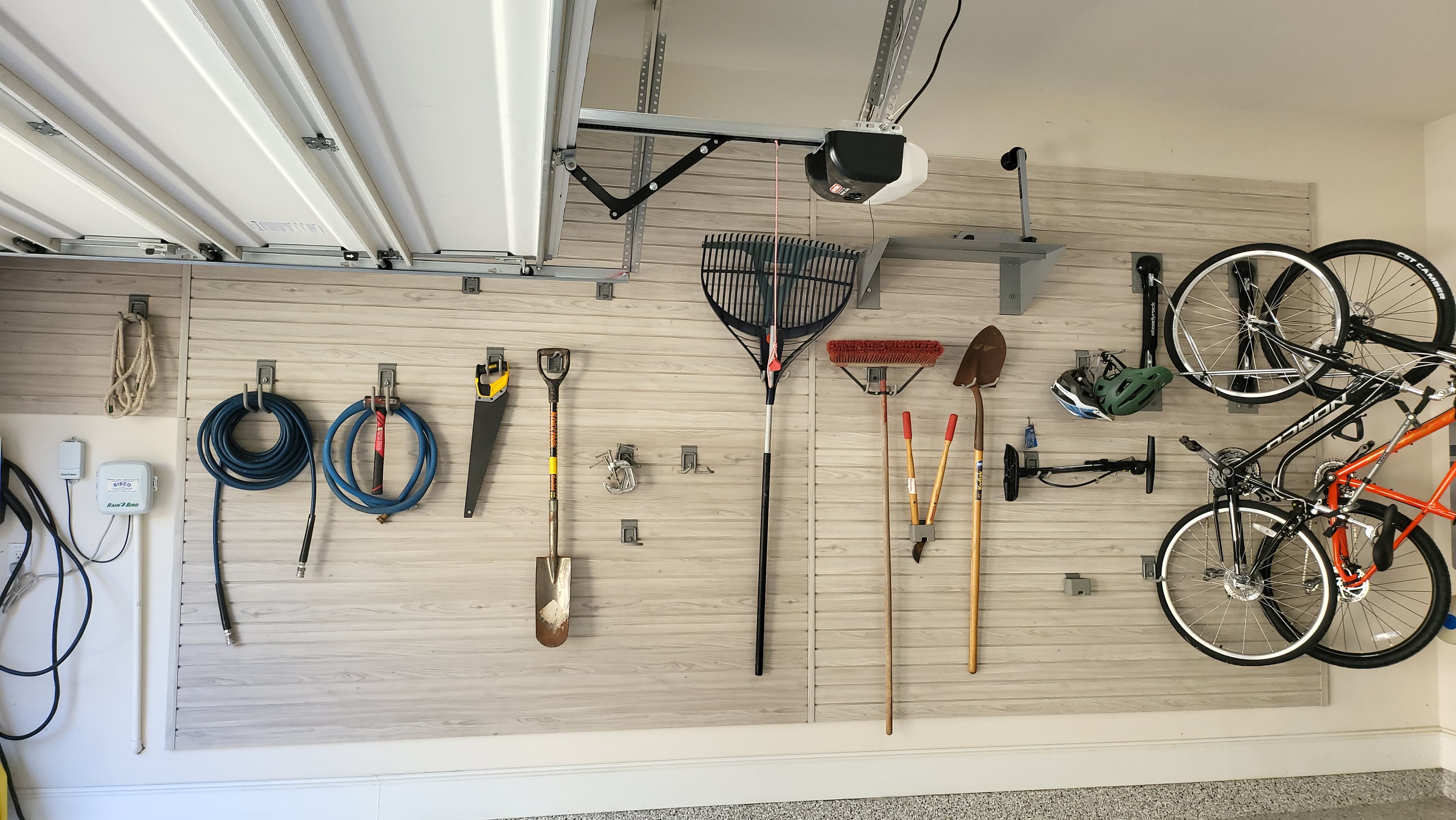 Full garage slatwall wall with bikes and garden tools